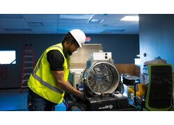 Techniker bedient Gebläse und Nebelmaschine zur Luftstromprüfung.