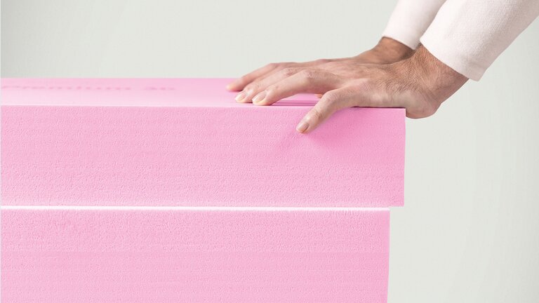 Rosa Dämmstoffplatten aus extrudiertem Polystyrol (XPS) gestapelt.