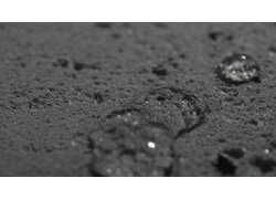 Wassertropfen perlen von der hochgradig hydrophoben Materialoberfläche ab.