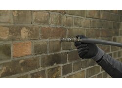 Einbringen von Kerndämmung in ein zweischaliges Mauerwerk.