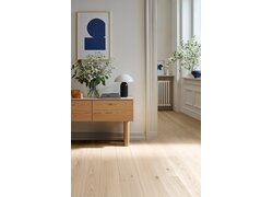 Helles Wohnzimmer mit Holzboden und Sideboard.