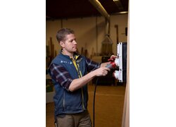 Handwerker steckt Industriestecker in Stromverteiler ein.