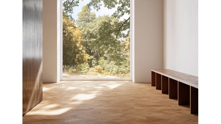 Helles Zimmer mit Fischgrätparkett und Waldblick.