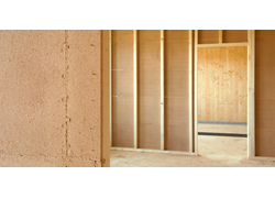 Holzständerwand im Innenausbau mit strukturierten Lehmbauplatten.