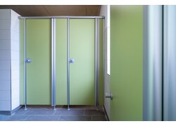 Grüne Toilettenkabinen mit silbernen Metallrahmen.