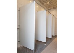 Weiße Toilettenkabinen mit grauen Fliesenboden.