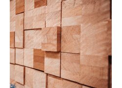 Strukturierte Wandgestaltung aus quadratischen Holzblöcken in Nahaufnahme.