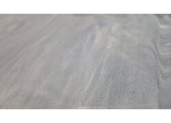  Nahaufnahme einer hellgrauen, leicht strukturierten Bodenoberfläche mit feinen Einschlüssen.