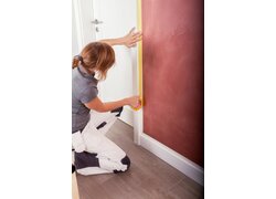 Auftragen eines Abdeckbandes als Vorbereitung für Malerarbeiten