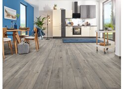 Wohnraum mit grauem Laminatboden in Eichenoptik.