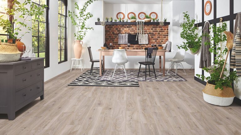 Gemütliches Esszimmer mit hellem Parkettboden und Ziegelwandakzent.