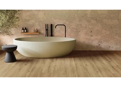 Badezimmer mit freistehender Badewanne und verlegtem hellem Holzboden in natürlicher Holzoptik