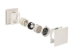 Das Bild zeigt ein in Einzelteile zerlegtes dezentrales Lüftungsgerät. Die Komponenten sind in einer Reihe angeordnet, von der äußeren Abdeckung über den Wärmespeicher, den Ventilator, Filterelemente bis hin zur Innenabdeckung mit Elektronikmodul. Die Darstellung veranschaulicht den Aufbau und die Funktionsweise des Lüftungssystems.