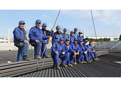 Eine Gruppe Baurbeiter in blauer Arbeitskleidung der Lotter Unternehmensgruppe auf Betonstahl und Baustahlmatten