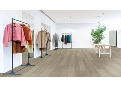 Modegeschäft mit Kleidungsständern und Holzfußboden.