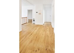 Heller Flur mit Eichenparkett und Türen.