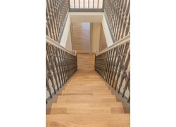 Treppe mit Eichenstufen und grauem Geländer.