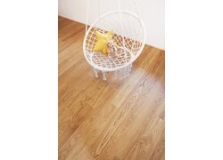 Großes Wohnzimmer mit Fischgrätparkett und Fensterfront.