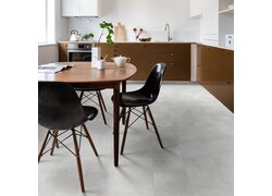 Moderne Küche mit braunen Schränken, runden Holztisch und schwarzen Stühlen.