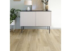 Helles Sideboard mit geriffelter Front, Pflanze und Deko auf Holzboden.