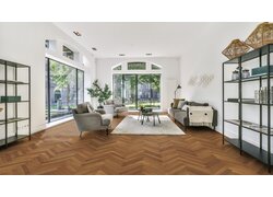 Helles Wohnzimmer mit Parkettboden im klassischen Fischgrät-Muster.