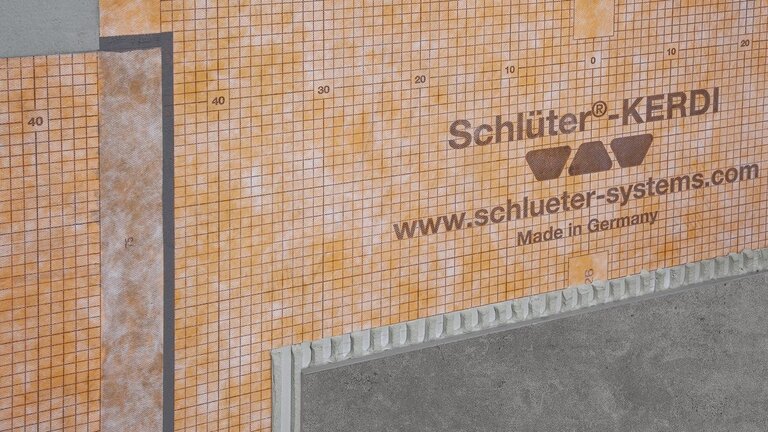 Mit Schlüter®-KERDI Abdichtungsmembran verkleidete Fläche, die für wasserdichte und langlebige Verkleidungen in Bauanwendungen konzipiert ist.