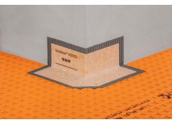Abdichtungsecken aus Polyethylen-Folie mit beidseitig eingebundenem Vliesgewebe auf einer orangefarbenen Entkopplungsmatte der Firma Schlüter.
