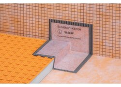 Abdichtungsecken aus Polyethylen-Folie mit beidseitig eingebundenem Vliesgewebe auf einer orangefarbenen Entkopplungsmatte der Firma Schlüter.