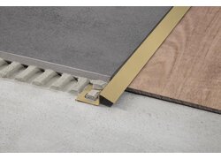  Nahaufnahme eines Bodenübergangsprofils aus Messing, das zwei unterschiedliche Bodenbeläge trennt.