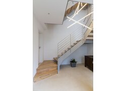 Moderne Holztreppe mit minimalistischer Metallgeländerführung