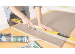 Person schneidet Dämmplatte mit Cuttermesser.