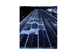 Eine große Industriehalle mit VAEPLAN Solar Dachbahnen und Solaranlagen darauf am Abend