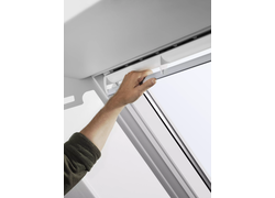 Hand öffnet Fenstergriff am Dachfenster