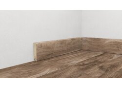 Holzfußbodenoptik mit Holzsockelleiste in Ecke.