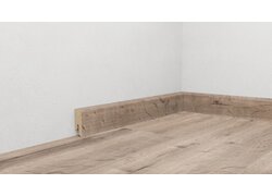 Holzfußbodenoptik mit Holzsockelleiste in Ecke.