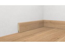 Holzfußbodenoptik mit Holzsockelleiste in Ecke.