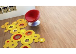 Roter Sessel, bunter Teppich, Holzfußboden.