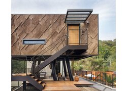 Modernes Haus auf Stelzen mit Korkfassade, Terrasse.