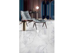 Eleganter Sessel auf glänzenden Fliesen in Marmoroptik.