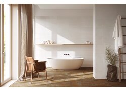 Helles Badezimmer mit freistehender Wanne und Holzstuhl.