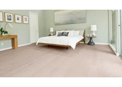 mafi Naturholzboden Esche in einem Schlafzimmer. Mittig das Bett mit Nachttisch rechts und links.