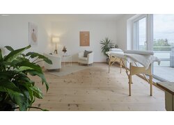 mafi Naturholzboden aus Nadelholz in einem Wellness- / Massagezimmer. Links zwei Sessel, rechts eine Liege und Fenster auf einen Balkon