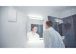 Mann im Badezimmer mit Wandlüftung