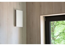 Wandlüftung in Holzverkleidung neben Fenster