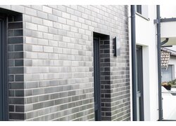 Ziegelwand mit Außenlüftung neben Tür