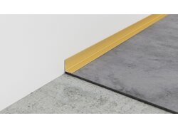 Goldfarbener Metallsockel trennt Wand und Bodenfläche