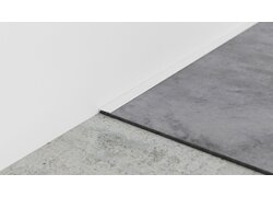 Weiße Metallkante trennt Wand und Bodenfläche