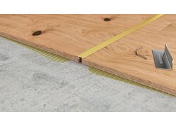 Gelbes Übergangsprofil zwischen Holzplatten