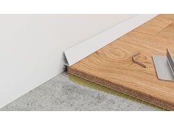 Weißes Abschlussprofil an Wand, Holzfußboden