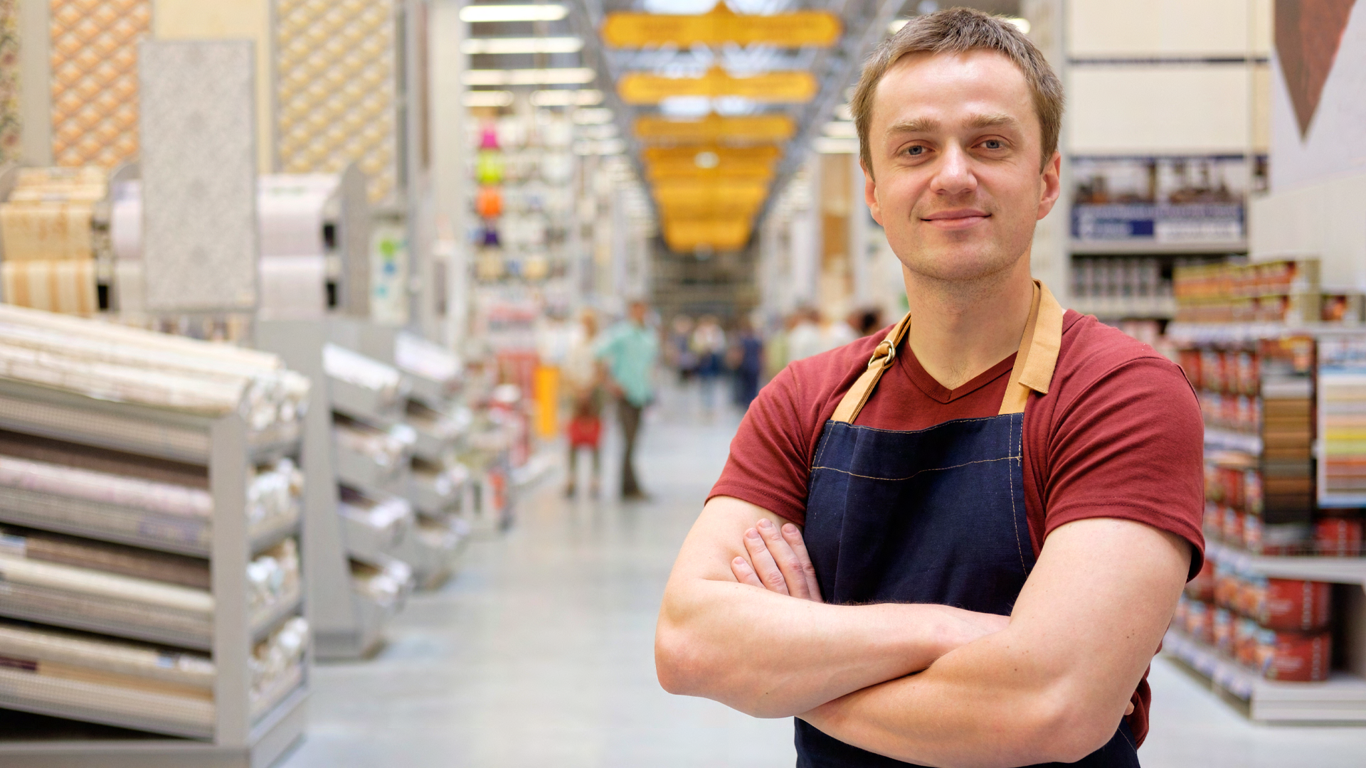 Verkaufen Sie ab jetzt gesunde Produkte Junger man steht mit verschränkten Amen in einem Baumarkt